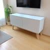 Rack blanco estilo nórdico con patas de madera para TV de hasta 43 pulgadas