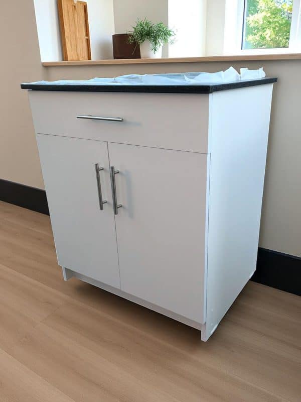 Mueble auxiliar blanco con cubierta de cuarzo negro galaxy, con cajón, puertas con cierre suave y tiradores metálicos modelo Madrid.