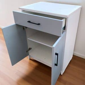 Mueble auxiliar de cocina con cubierta de cuarzo blanco galaxy, melamina blanca, puertas gris humo y tiradores negros, ideal para espacios pequeños.