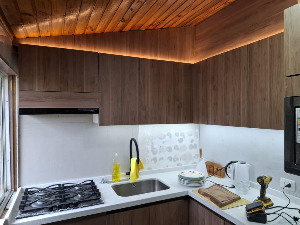 Cocina Instalada en Algarrobo villa Buen Retiro, iluminacion led en la parte superior con led calido, en inferior luz fria, melamina color caramel, cubierta cuarzo snowflake