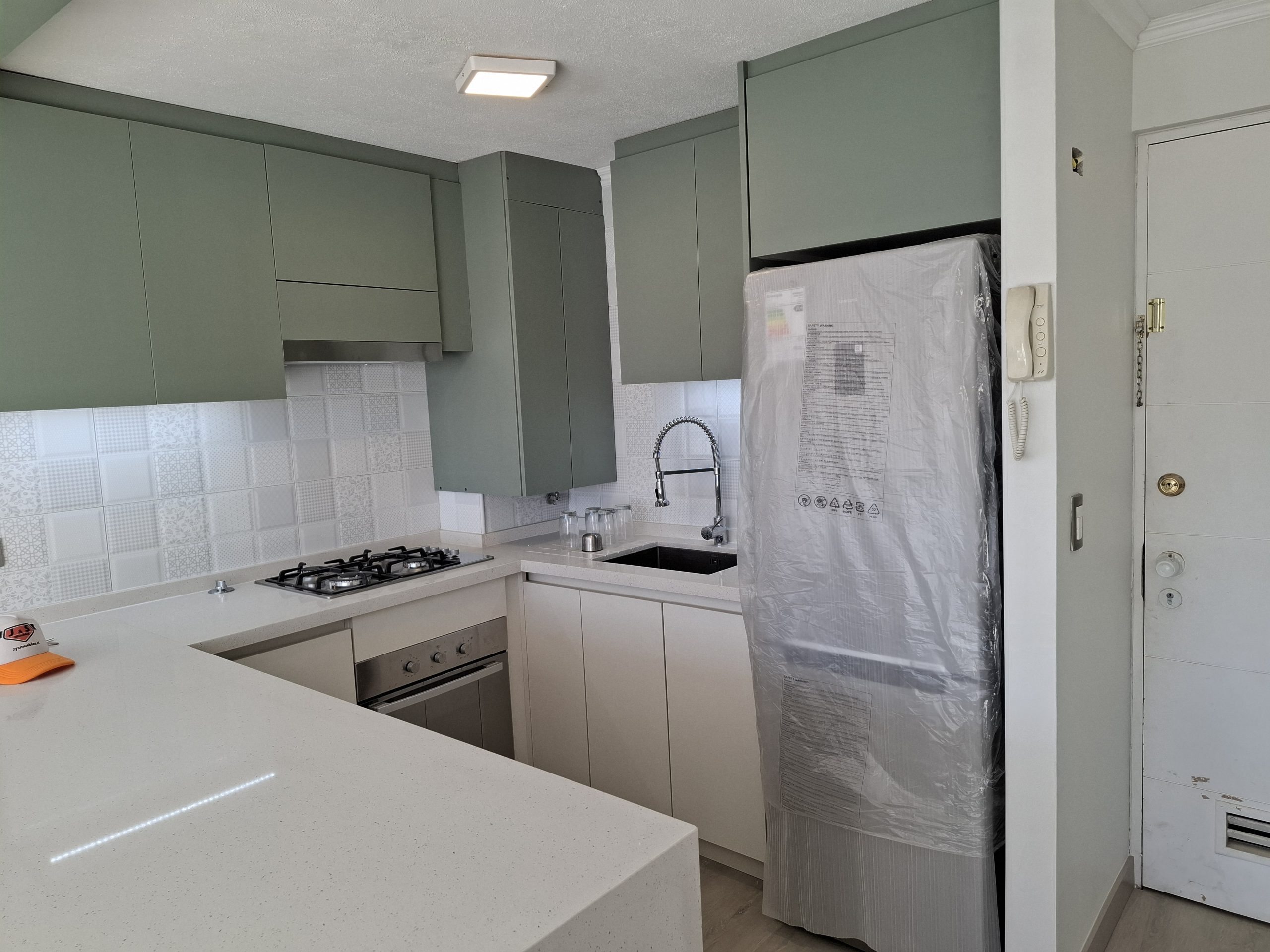 Cocina remodelada con muebles superiores de melamina jade, inferiores tatami y cubierta de cuarzo blanco Galaxy