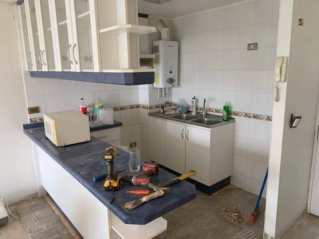 Cocina antes de la remodelación con cubierta postformada y muebles de melamina desgastados